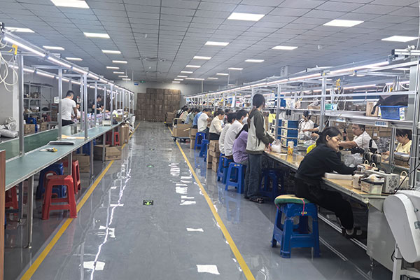Workers on a speaker assembly line
