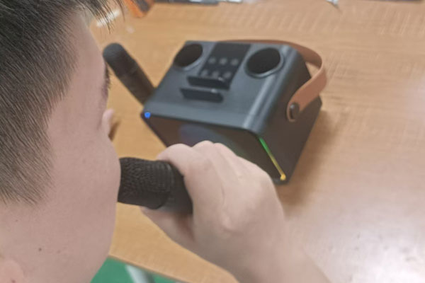 A quality control inspector testing a Bluetooth speaker